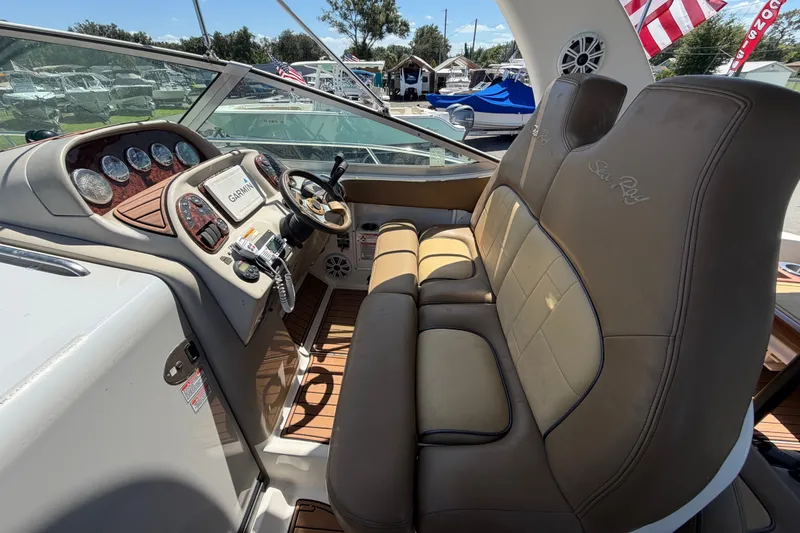 Slide: The Image of 2006 Sea Ray 300 Sundancer cockpit with leather seats and modern dashboard controls. - 27