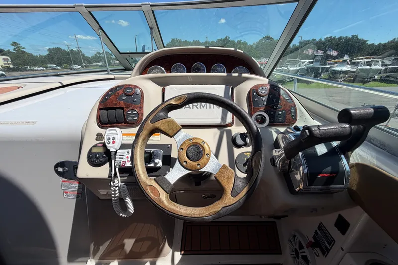 Slide: The Image of Cockpit of 2006 Sea Ray 300 Sundancer with steering wheel and control panel. - 28