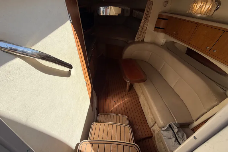 Slide: The Image of Interior of 2006 Sea Ray 300 Sundancer yacht with beige seating and wooden accents. - 55