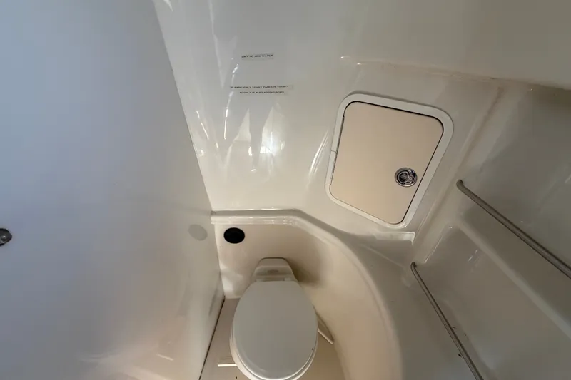 Slide: The Image of 2006 Sea Ray 300 Sundancer boat bathroom with toilet and storage compartment. - 61