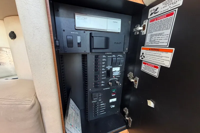 Slide: The Image of Electrical control panel inside a 2006 Sea Ray 300 Sundancer boat, featuring various switches and warnings. - 94