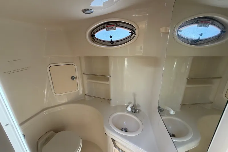 Slide: The Image of Bathroom interior of 2006 Sea Ray 300 Sundancer yacht with sink, toilet, and porthole window. - 59