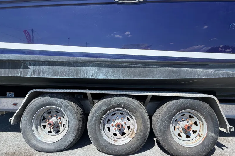 Slide: The Image of Trailer with Sea Ray 300 Sundancer boat, 2006 model, showing triple axle wheels. - 118