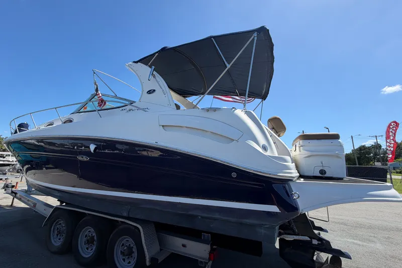 Slide: The Image of 2006 Sea Ray 300 Sundancer boat on trailer under clear blue sky. - 9