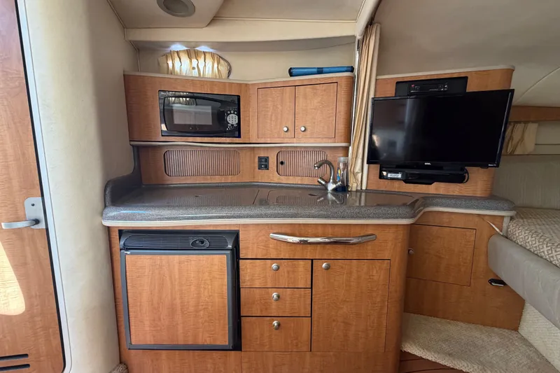 Slide: The Image of 2006 Sea Ray 300 Sundancer interior with kitchenette, microwave, TV, and compact fridge. - 66