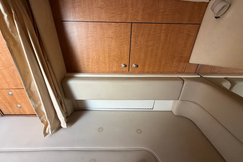 Slide: The Image of Interior of 2006 Sea Ray 300 Sundancer with wood cabinets and beige seating. - 100