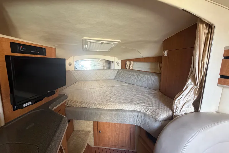 Slide: The Image of 2006 Sea Ray 300 Sundancer cabin interior with bed, TV, and wood accents. - 21