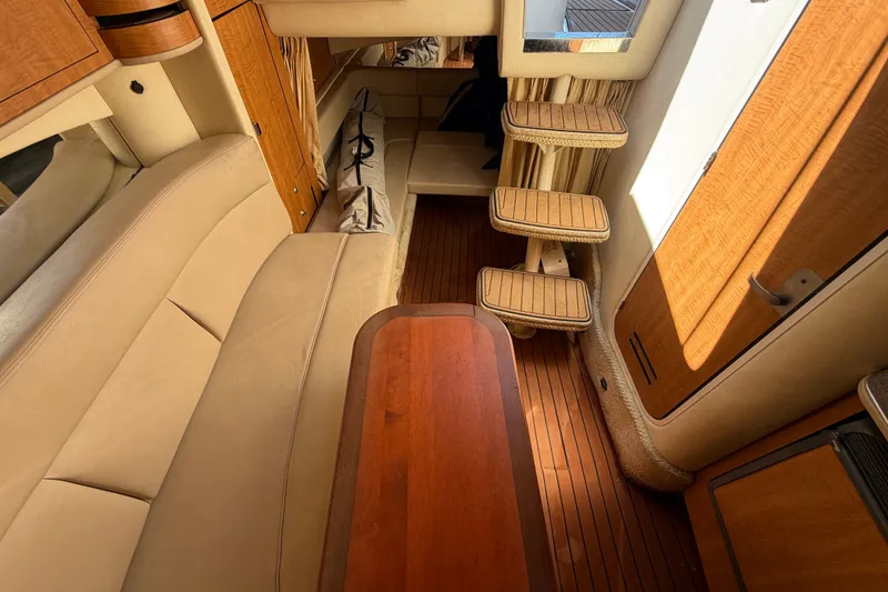 Slide: The Image of Interior of 2006 Sea Ray 300 Sundancer with beige seating and wooden accents. - 89