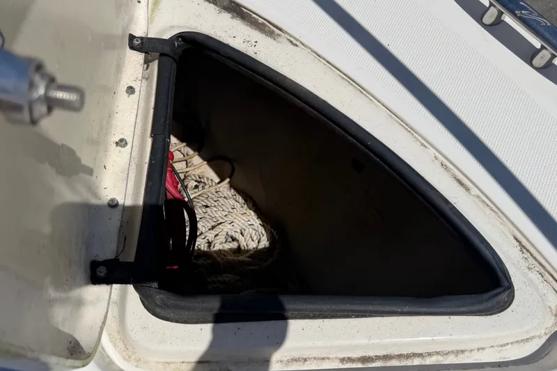 Slide: The Image of An open storage compartment on a boat with ropes inside. - 48