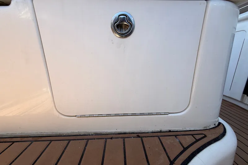 Slide: The Image of 2006 Sea Ray 300 Sundancer boat deck with storage compartment and teak flooring. - 106