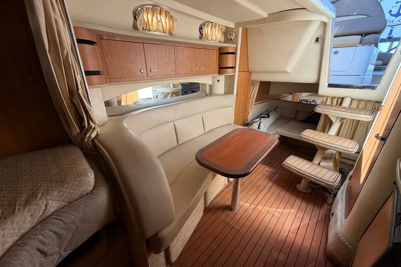 Slide: The Image of Luxurious interior of 2006 Sea Ray 300 Sundancer with wood accents and plush seating. - 85