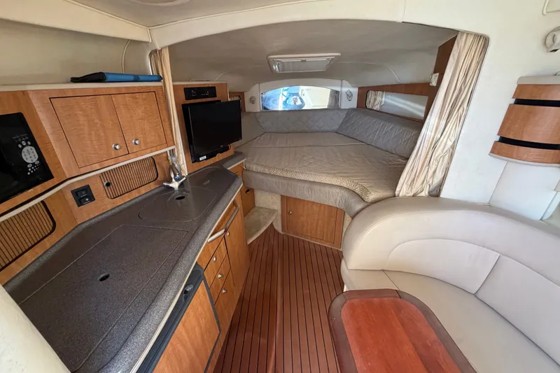 Slide: The Image of Interior of 2006 Sea Ray 300 Sundancer with kitchenette, bed, and seating area. - 65
