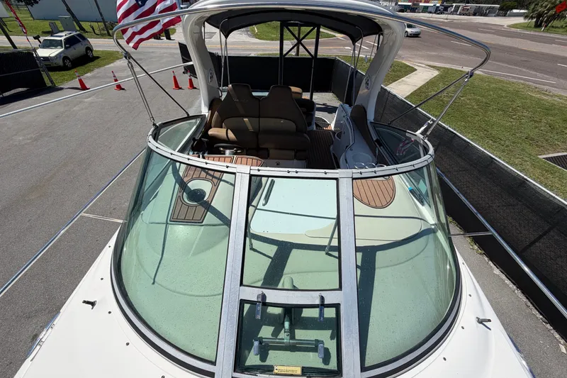 Slide: The Image of 2006 Sea Ray 300 Sundancer boat with American flag, docked on a sunny day. - 53
