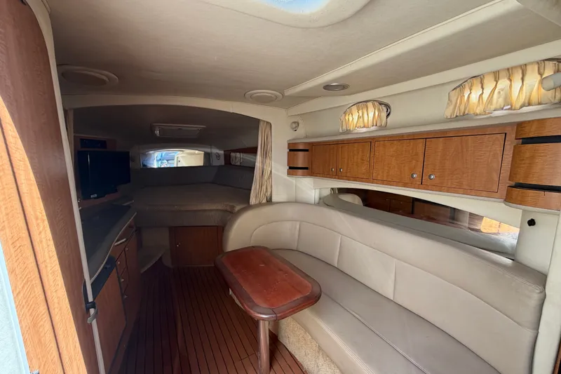 Slide: The Image of Interior of 2006 Sea Ray 300 Sundancer with cozy seating and wooden cabinetry. - 56