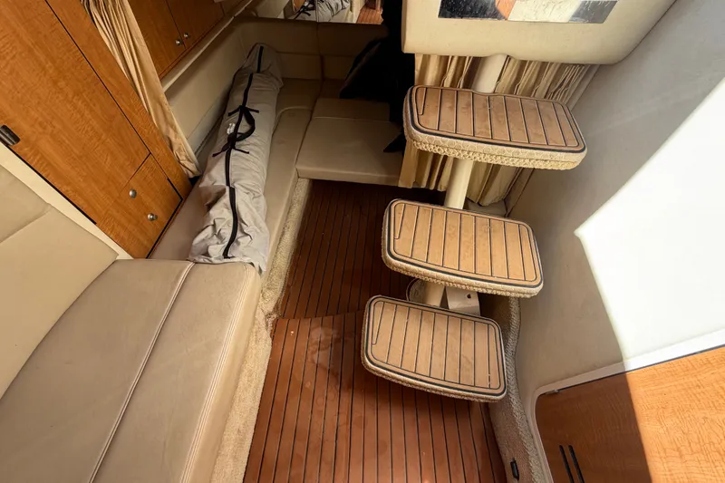 Slide: The Image of Interior of 2006 Sea Ray 300 Sundancer with wooden flooring and seating area. - 90