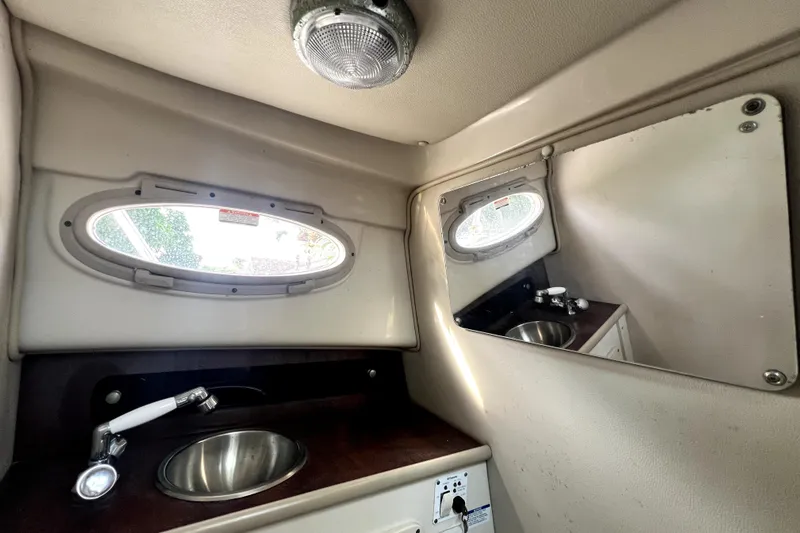 Slide: The Image of 2014 Robalo R265 Walkaround cabin interior with sink and mirror. - 75