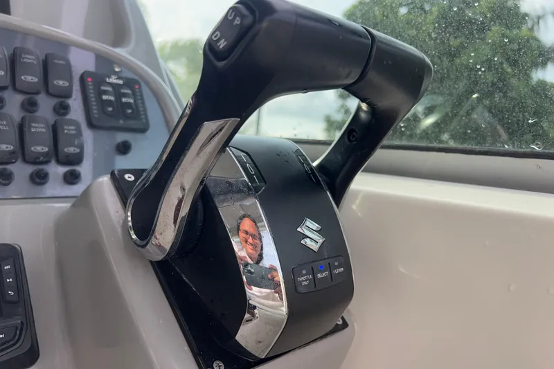 Slide: The Image of Close-up of 2014 Robalo R265 Walkaround boat throttle control with Suzuki logo. - 132
