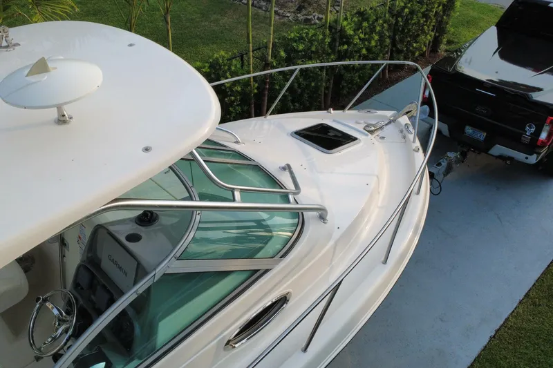 Slide: The Image of 2014 Robalo R265 Walkaround boat hitched to a black truck on a driveway. - 26