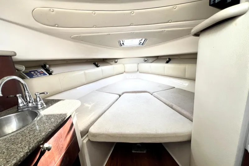 Slide: The Image of 2014 Robalo R265 Walkaround cabin interior with seating and compact kitchenette. - 123