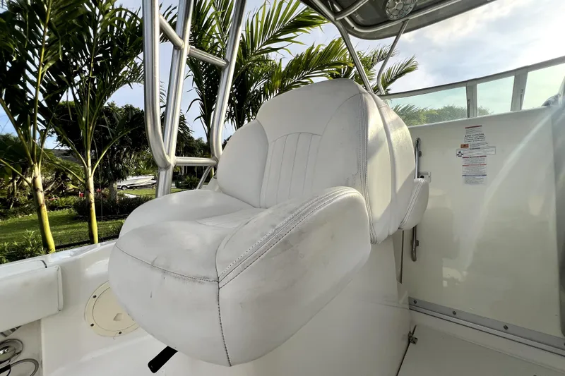 Slide: The Image of Een witte kapiteinsstoel op een boot, omgeven door palmbomen op de achtergrond. - 59