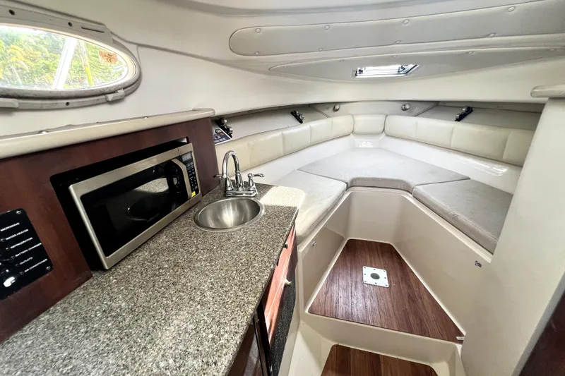 Slide: The Image of 2014 Robalo R265 Walkaround cabin interior with kitchenette, sink, and seating area. - 71