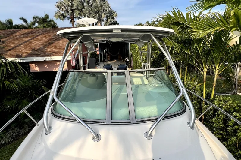 Slide: The Image of Een Robalo R265 Walkaround boot staat op het land, omringd door palmbomen en een huis. - 49