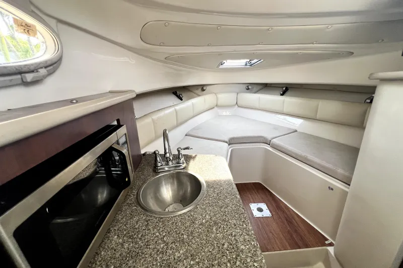 Slide: The Image of 2014 Robalo R265 Walkaround cabin interior with kitchenette and seating area. - 66