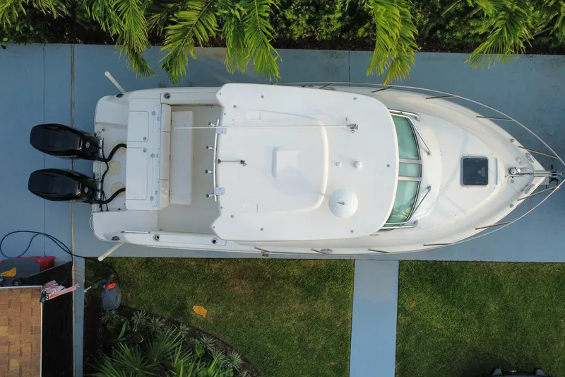 Slide: The Image of Overhead view of a 2014 Robalo R265 Walkaround boat on a driveway, surrounded by greenery. - 27