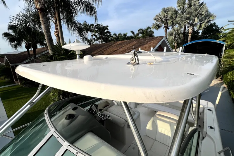 Slide: The Image of 2014 Robalo R265 Walkaround boat with hardtop, surrounded by tropical palm trees. - 45
