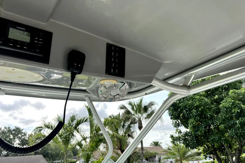 Slide: The Image of 2014 Robalo R265 Walkaround boat interior with Garmin electronics and lush greenery background. - 82