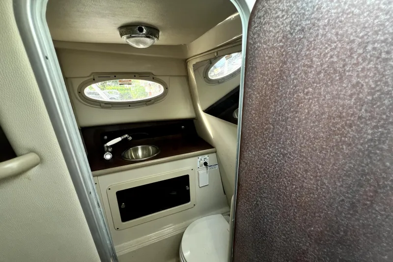 Slide: The Image of 2014 Robalo R265 Walkaround boat interior with sink and toilet. - 124