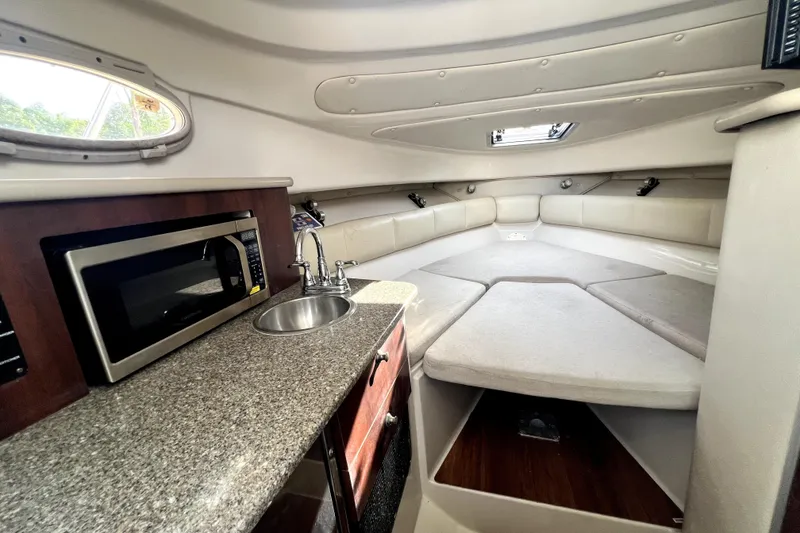 Slide: The Image of 2014 Robalo R265 Walkaround cabin interior with kitchenette and cozy seating area. - 69