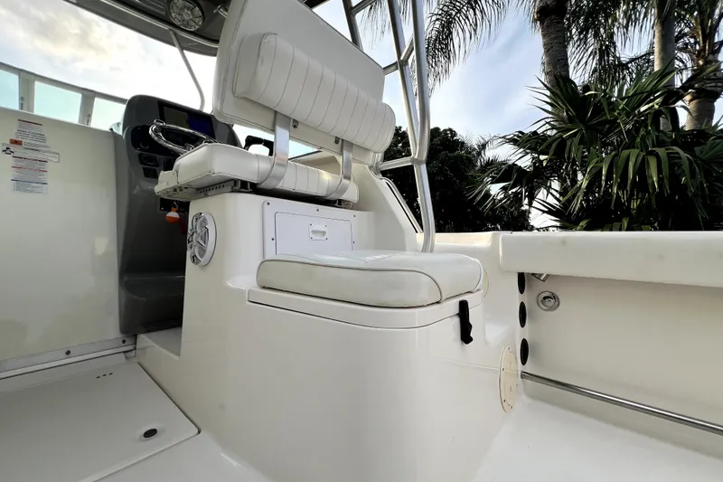 Slide: The Image of 2014 Robalo R265 Walkaround boat interior with helm seat and tropical backdrop. - 106