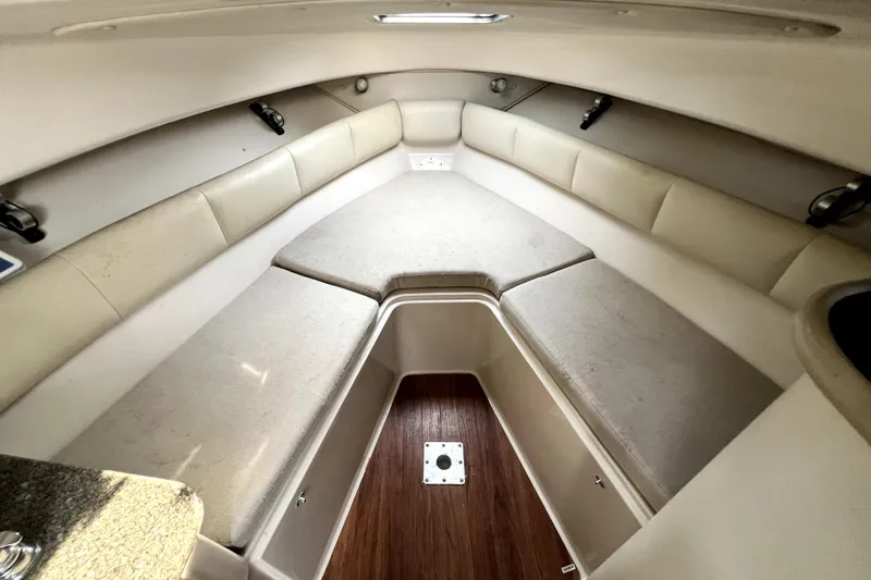 Slide: The Image of 2014 Robalo R265 Walkaround cabin interior with cushioned seating and wood flooring. - 65
