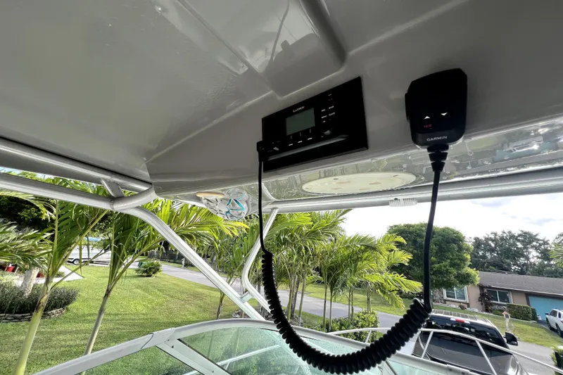 Slide: The Image of 2014 Robalo R265 Walkaround boat with Garmin marine electronics, surrounded by lush greenery. - 83
