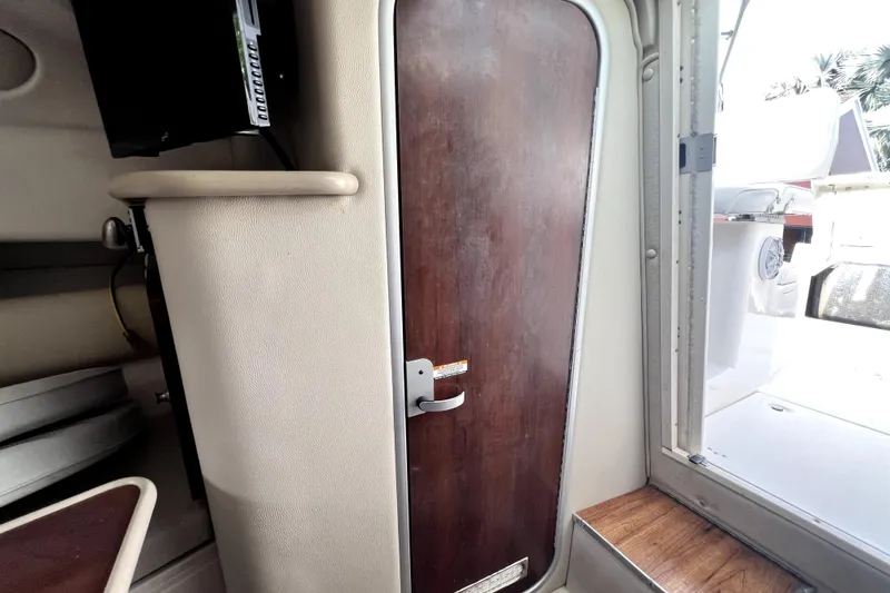 Slide: The Image of Interior view of 2014 Robalo R265 Walkaround boat cabin door and seating area. - 125