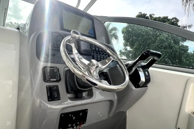 Slide: The Image of Helm of 2014 Robalo R265 Walkaround boat with steering wheel and controls. - 131