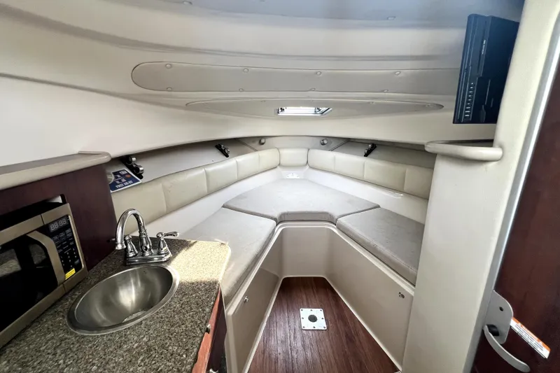 Slide: The Image of 2014 Robalo R265 Walkaround cabin interior with kitchenette and seating area. - 67