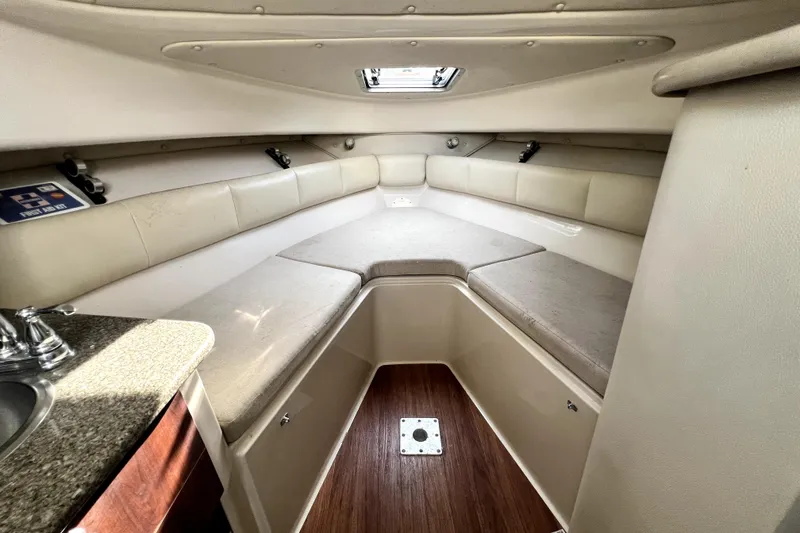 Slide: The Image of 2014 Robalo R265 Walkaround cabin interior with cushioned seating and compact kitchenette. - 70
