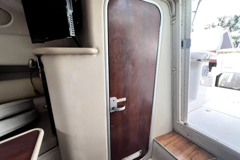 Slide: The Image of Interior cabin view of 2014 Robalo R265 Walkaround boat with wooden door. - 126