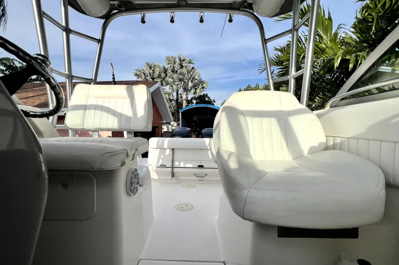 Slide: The Image of 2014 Robalo R265 Walkaround boat interior with white seating and steering wheel. - 116