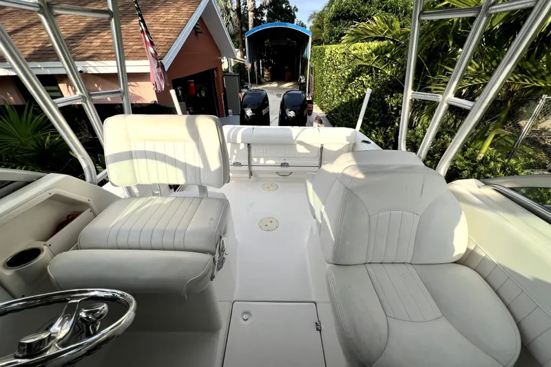 Slide: The Image of 2014 Robalo R265 Walkaround boat interior with white seating and steering wheel. - 60