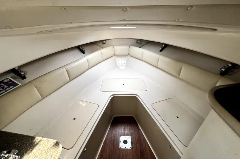 Slide: The Image of 2014 Robalo R265 Walkaround cabin interior with cushioned seating and storage compartments. - 64