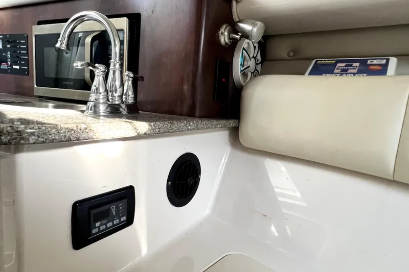 Slide: The Image of 2014 Robalo R265 Walkaround interior with sink, microwave, and first aid kit. - 120