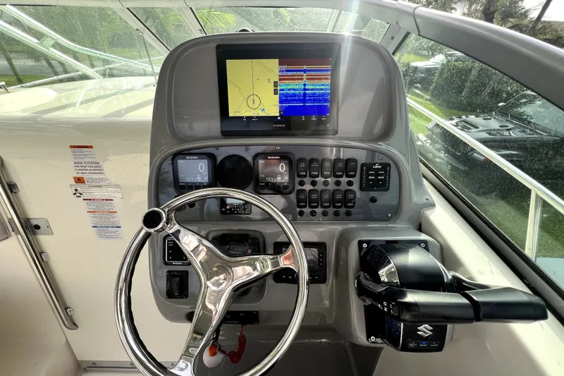 Slide: The Image of 2014 Robalo R265 Walkaround helm with steering wheel, navigation display, and control panel. - 86