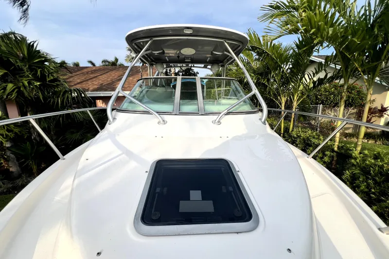 Slide: The Image of 2014 Robalo R265 Walkaround boat with sleek deck and lush surroundings. - 92