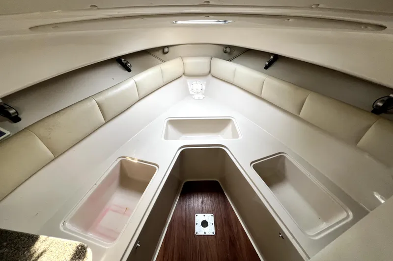 Slide: The Image of 2014 Robalo R265 Walkaround cabin interior with cushioned seating and storage compartments. - 63
