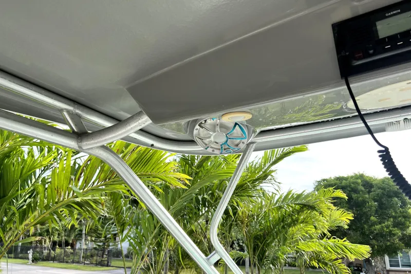 Slide: The Image of 2014 Robalo R265 Walkaround boat interior with speaker and lush greenery background. - 81
