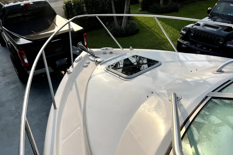 Slide: The Image of 2014 Robalo R265 Walkaround boat bow with railing, parked near trucks. - 47