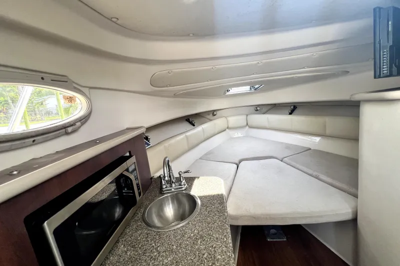 Slide: The Image of 2014 Robalo R265 Walkaround cabin interior with kitchenette and seating area. - 68
